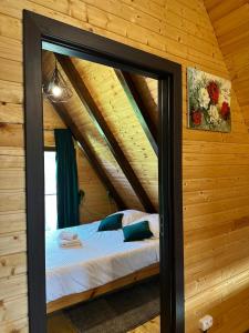 ein Schlafzimmer mit einem Bett in einer Holzhütte in der Unterkunft Cabana Arunia in Buninginea