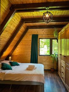 a bedroom with a bed in a wooden house at Cabana Arunia in Buninginea