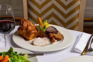 a plate of food with meat and vegetables on a table at Roslin Beach Hotel in Southend-on-Sea