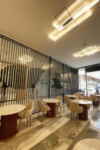 Un restaurante con mesas y sillas y un balcón. en Royal Mass Airport Business Hotel, en Arnavutköy