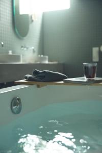 a bathroom with a sink and a bath tub with a glass at At Hotel ORTO in Fukuoka +29 photos