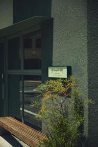 a sign on the side of a building with a bench at At Hotel ORTO in Fukuoka