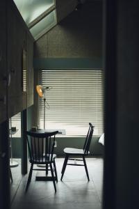 a room with a table and two chairs and a lamp at At Hotel ORTO in Fukuoka