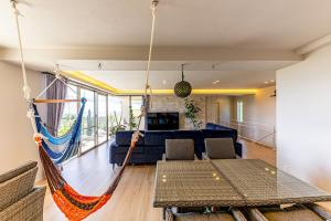 a room with a hammock in a living room at Laguna Fuchaku in Onna