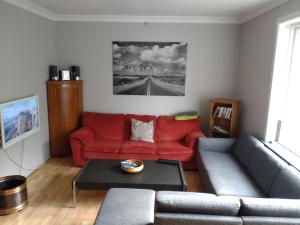 a living room with a red couch and a table at Fjordshelter vintage townhouse in Tysso
