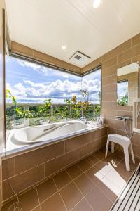 a large bathroom with a tub and a large window at Laguna Fuchaku in Onna +108 photos