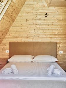 Cama grande en habitación con pared de madera en Sea Wood Villas, en Golem 6 fotos más