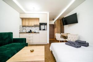 a living room with a bed and a green couch at Panorama V Lux Vrnjačka Banja in Vrnjačka Banja +45 photos