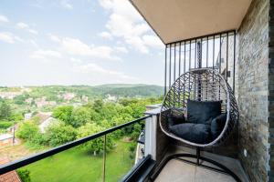 a hanging rattan chair on a balcony with a view at Panorama V Lux Vrnjačka Banja in Vrnjačka Banja