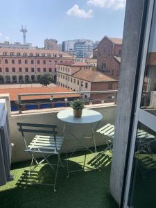 Una mesa y sillas en un balcón con vista. en MILANO 71 HOME, en Milán
