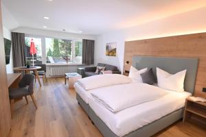 a bedroom with a large bed and a living room at Alpenhof Apartments Oberstdorf in Oberstdorf