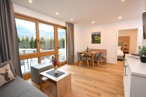 a living room with a couch and a table at Alpenhof Apartments Oberstdorf in Oberstdorf