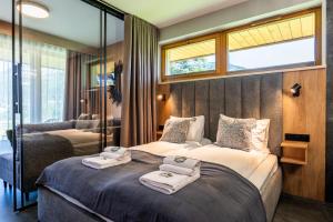a hotel room with two beds with towels on them at Wypasiona Polana by Apart Concept Podhale in Kościelisko +22 photos