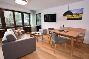 a living room with a table and a couch at Alpenhof Apartments Oberstdorf in Oberstdorf