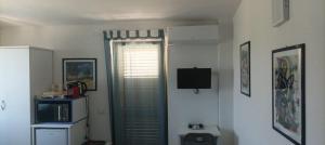 a room with a window with a television in it at Gullo Capo Vaticano in Ricadi