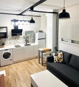 a living room with a couch and a kitchen at Loft A Mariña Lucense in San Ciprián