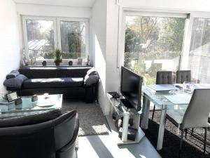 Una sala de estar con un sofá y un televisor. en Ferienwohnung Morgentau, en Bad Pyrmont