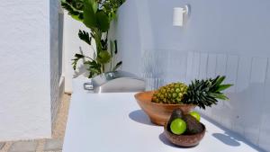 a bowl of fruit on a counter next to a bowl of pineapple at EBLI7 Hotel Boutique in Orihuela Costa