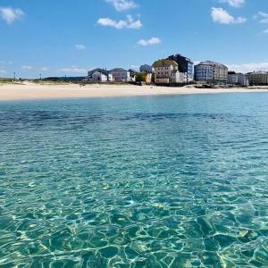 a body of water with a beach in the background at Loft A Mariña Lucense in San Ciprián