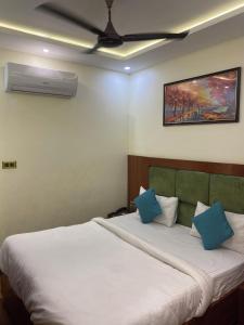 a bedroom with a large white bed with blue pillows at Hotel Ramesh Palace in Prayagraj
