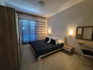 a bedroom with a bed with two pillows and a window at Apartments Margareta & Ena in Malinska