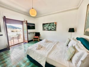 ピアノ・ディ・ソレントにあるRoof top Casa Izzoの大きな白いベッドと椅子のある寝室