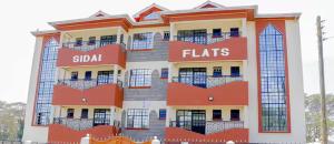 a tall building with red and white at Cosy 1 bedrooms, Hells Gate Moi South Lake Naivasha in Naivasha