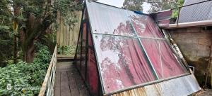 a house with a glass door on a wooden deck at Nest 'N' Woods in Ooty +1 photo