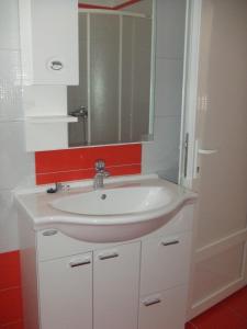un baño con lavabo y espejo en Apartments Diva, en Novalja