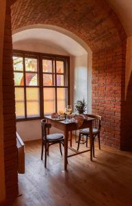 a dining room with a table and chairs and a brick wall at Ubytování na pevnosti in Olomouc