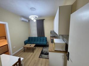 a living room with a blue couch and a table at Green Escape Apartment Tirana in Tirana
