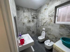 a bathroom with a sink and a toilet at Green Escape Apartment Tirana in Tirana