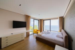 ein Schlafzimmer mit einem Bett und einem Schreibtisch mit Fernseher in der Unterkunft Villa Patria in Budva