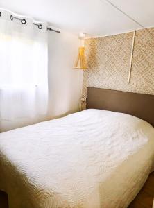 sypialnia z białym łóżkiem i oknem w obiekcie Mobil-home au camping 5 étoiles L'Oasis Village - Montana Parc w mieście Puget-sur Argens