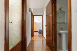 einen Flur, der zu einem Bad mit einem Waschbecken führt in der Unterkunft Balconcino Vista Mare by BarbarHouse in San Foca + 14 Fotos