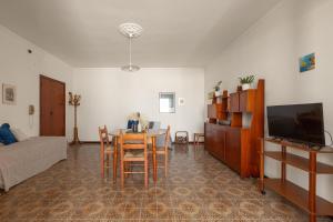 ein Wohnzimmer mit Tisch und Fernseher in der Unterkunft Balconcino Vista Mare by BarbarHouse in San Foca