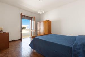 ein Schlafzimmer mit blauem Bett und Balkon in der Unterkunft Balconcino Vista Mare by BarbarHouse in San Foca