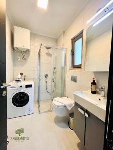 a bathroom with a shower toilet and a washing machine at Kargı Suites Datça in Datca +50 photos