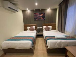 una camera d'albergo con due letti in una stanza di President Hotel Airport a Kathmandu