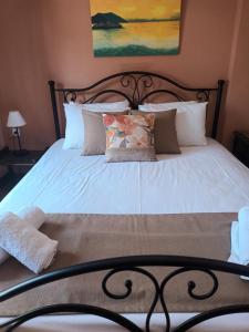 a bed with white sheets and pillows at Dionisis Apartments in Kounopetra