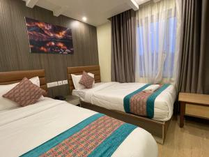 una camera d'albergo con due letti e una finestra di President Hotel Airport a Kathmandu