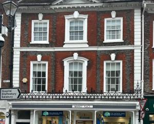 a large brick building with white windows on a street at Single Room in Georgian Masionette in Blandford Forum