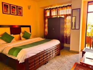 a bedroom with a large bed with green pillows at Hotel Om Palace Mcleodganj Himachal Pradesh in Dharamshala