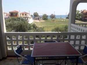 a table on a balcony with a view of the ocean at olivensun apartment 6 in Gythio +4 photos