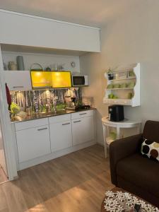 sala de estar con cocina con armarios blancos en Hotelli Terme 616, en Kilvakkala