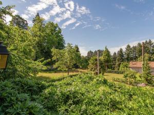 a garden with trees and bushes in a field at Romantic cottage with shared swimming pool in Roussines