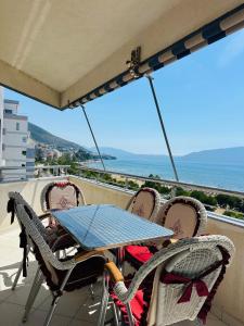 un tavolo e sedie su un balcone con vista sull'oceano di Blue Escape Apartment Lungo Mare a Vlorë