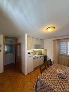 a kitchen and dining room with a table and a table and chairs at Apartment Stana in Petrovac na Moru