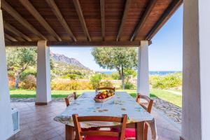 a table with a bowl of fruit on a patio at Villa Azzurra con piscina in Tertenìa