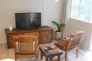 a living room with two chairs and a flat screen tv at One on Old Main Unit 8 in Hillcrest